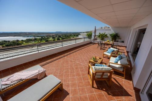 a balcony with chairs and tables and a view at Mediterranean & golf dreams in Alicante