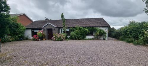 a white house with flowers in front of it at Foxglove House in Douglas