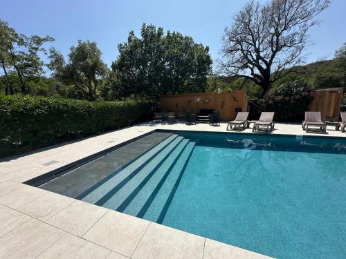 a swimming pool with two lounge chairs at Le Mas Saint Donat in Sainte-Maxime