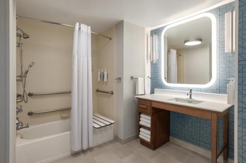 a bathroom with a sink and a tub and a shower at Homewood Suites Fort Myers Airport - FGCU in Fort Myers