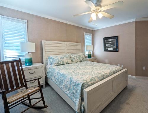 a bedroom with a bed and a fan and a chair at Seaside Sea Esta in Corolla