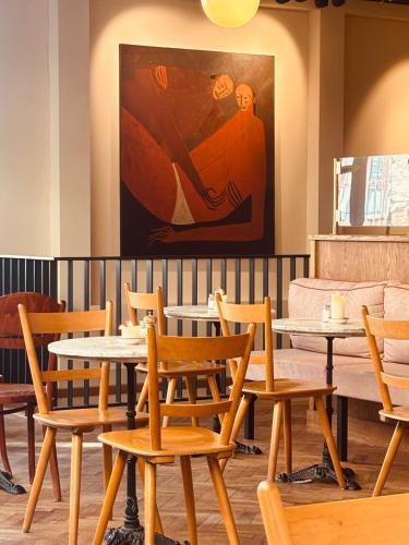 a room with tables and chairs and a painting at Metzlr House in Haarlem