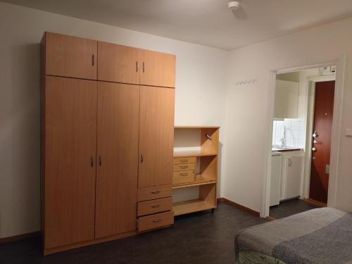 a bedroom with a large wooden cabinet and a bed at Sun life room in Stockholm