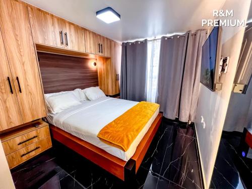 a bedroom with a bed with an orange blanket on it at R&M Premium in Baños
