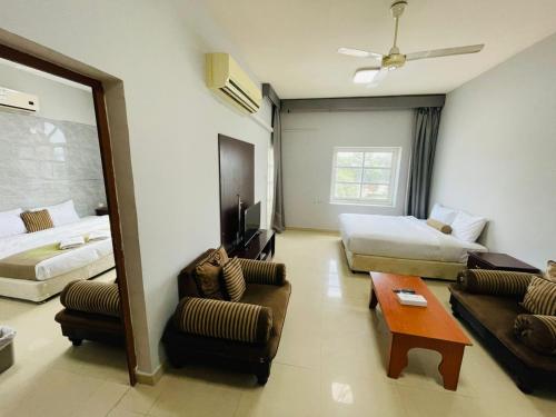 a hotel room with a bed and a living room at Cozy 1 Bedroom Hall in Khor Fakkan