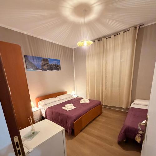 a bedroom with two beds and a table and a ceiling at B&B Dora 2,0 in Praia a Mare