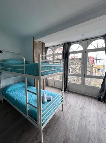 a bedroom with two bunk beds in a room at Albergue Mar del Plata in Fisterra