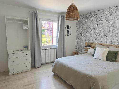 a bedroom with a bed and a dresser and a window at Maison d'hôtes - La Forge de Clermont in Clermont
