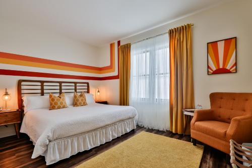 a bedroom with a large bed and a chair at Urban Collective Boutique Hotel in Edwardsville