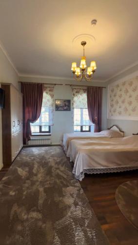 a bedroom with two beds and a chandelier at Comfort Villa Sheki in Sheki