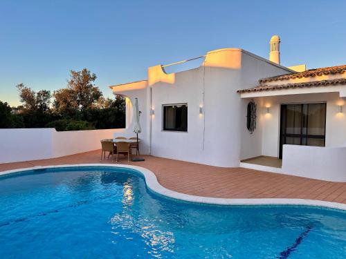 a villa with a swimming pool in front of a house at Villa Tara Christina in Carvoeiro