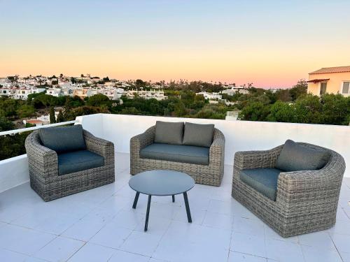 three chairs and a table on a balcony with a view at Villa Tara Christina in Carvoeiro