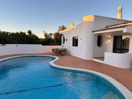 a swimming pool in front of a house at Villa Tara Christina in Carvoeiro