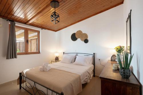 a bedroom with a bed and a wooden ceiling at Skyloft - Rooftop Jacuzzi & Sea View - Central Kos in Kos