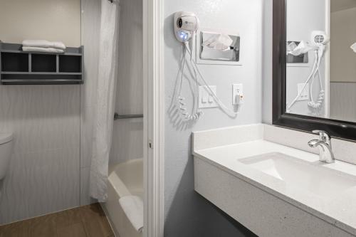 a bathroom with a sink and a phone on the wall at Sand Dollar Inn in Seaside