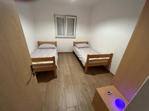 a room with two beds and a window at Apartman Caminito in Zadar