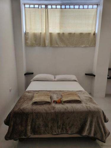 a bedroom with a bed with two towels on it at Galápagos Finch Apartment in Puerto Ayora