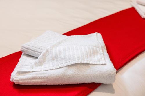 a pile of white towels sitting on a red blanket at Mandalay Cozy & Affordable Apartment with Patio in Mellieħa