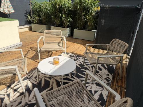 un patio con sedie e un tavolo con un drink sopra di Le Chouette Loft a Digione