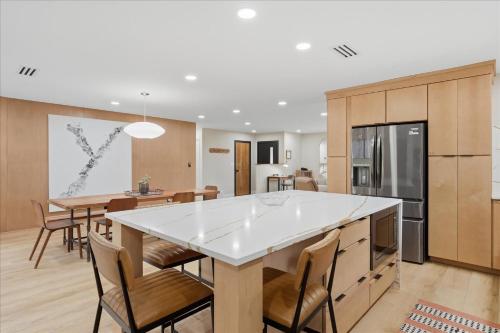 a kitchen and dining room with a large white island at Yosemite Outpost in Oakhurst