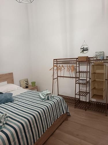 a bedroom with a bed with a striped blanket at Casetta d'Ossuna in Palermo