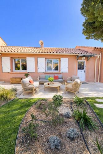 a patio with chairs and a table in front of a house at Villa Clemarine - Piscine & Jacuzzi in Sanary-sur-Mer