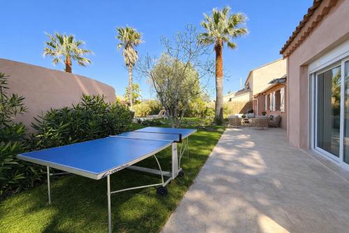 a ping pong table in a yard with palm trees at Villa Clemarine - Piscine & Jacuzzi in Sanary-sur-Mer