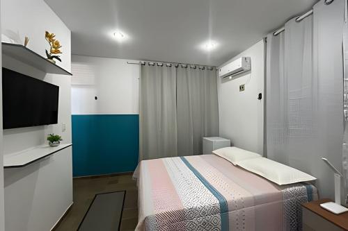 a small bedroom with a bed and a television at Studio Caju in Mossoró