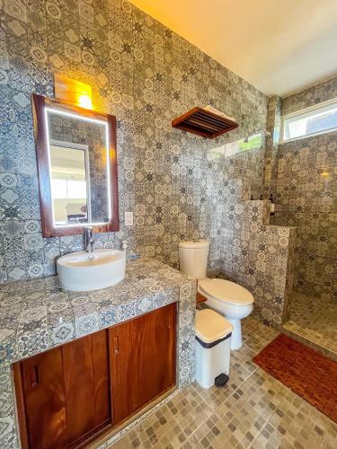 a bathroom with a sink and a toilet and a mirror at Valentina Salchi Bay virgin beaches fast internet in Cuatunalco