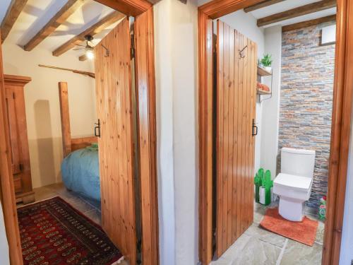 a bathroom with wooden doors and a toilet at The Ranch in Prestatyn