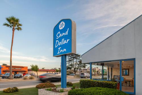 a sign for a sand dollar inn in front of a building at Sand Dollar Inn in Seaside