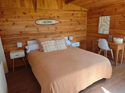 a bedroom with a bed in a log cabin at Le Chalet des Pins - La Forge De Clermont in Clermont