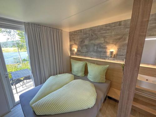 a hotel room with a bed and a window at Feriendorf Seeblick - Tiny Chalet Nr 8 in Neunburg vorm Wald