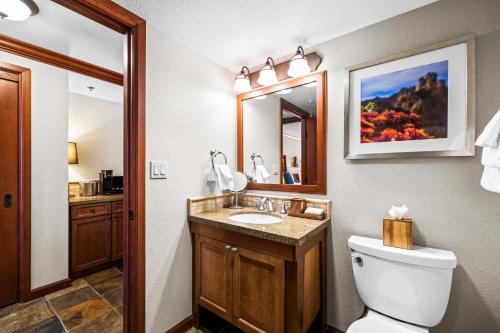 a bathroom with a toilet and a sink and a mirror at Olympic Valley Summer Stay: Everline Resort & Spa! in Olympic Valley
