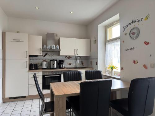 a kitchen with a table and chairs and a refrigerator at Ferienwohnung in Ballenstedt in Ballenstedt