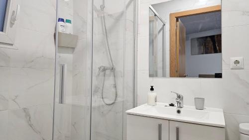 a white bathroom with a shower and a sink at Golden Tower Rooms - auto check-in in Gandía