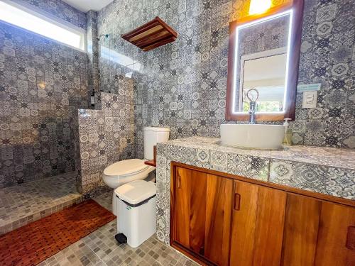 a bathroom with a toilet and a sink and a mirror at Valentina Salchi suites virgin beaches internet in Cuatunalco