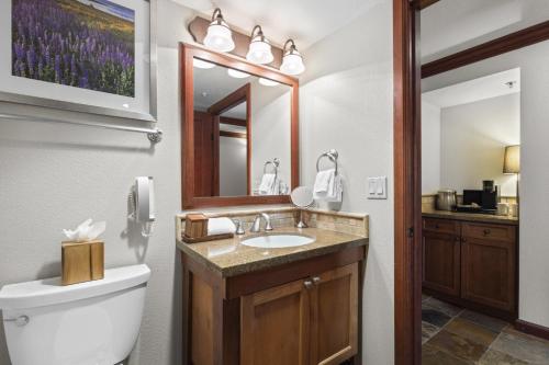 a bathroom with a sink and a toilet and a mirror at Valley-View Unit in Everline Resort: Premier Perks in Olympic Valley