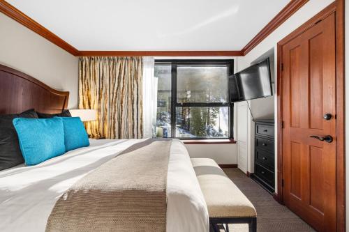 a bedroom with a large bed and a window at Pool, Hot Tub & Golf: Everline Resort Corner Suite in Olympic Valley