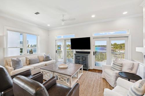 a living room with white furniture and a flat screen tv at Dock N Dune by 30A Escapes in Seagrove Beach