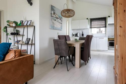 a kitchen and dining room with a table and chairs at Rekerlanden 275 in Warmenhuizen