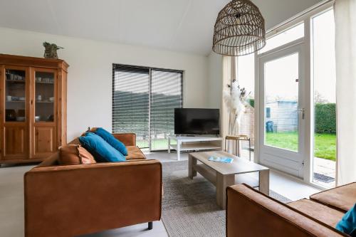 a living room with two couches and a tv at Rekerlanden 275 in Warmenhuizen