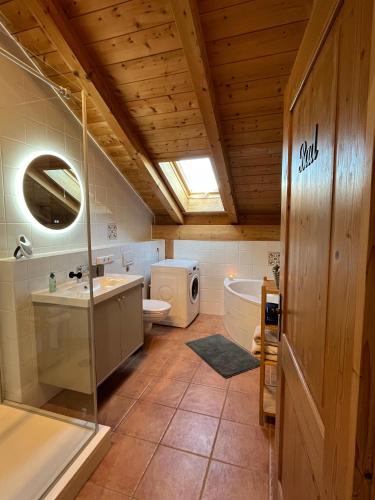 a bathroom with a toilet and a sink and a tub at Heidis Ferienwohnung Abendlicht in Egling