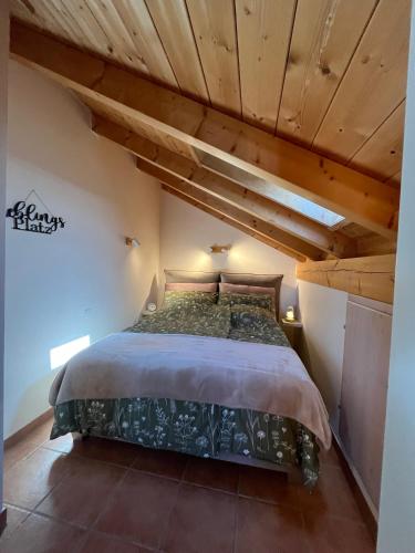 a bedroom with a bed in a room with wooden ceilings at Heidis Ferienwohnung Abendlicht in Egling