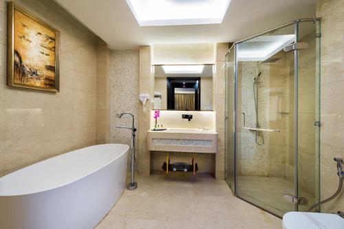 a bathroom with a tub and a shower and a sink at Boudl Al Sahafa in Riyadh