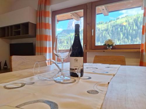 a bottle of wine and a glass on a table at Apartments Insam in Santa Cristina Gherdëina
