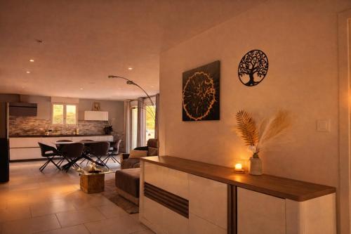 a kitchen and a living room with a couch and a table at Maison avec piscine in Golbey