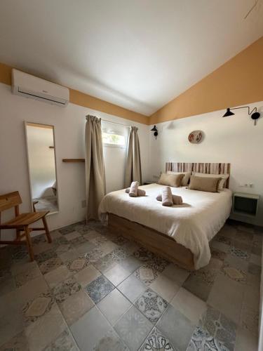 a bedroom with a large bed and a mirror at Casita Malacitano, Caminito del Rey in Valle de Abdalagís