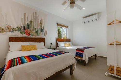 a bedroom with two beds and a ceiling fan at Baja Beach Pad at Cerritos in El Pescadero
