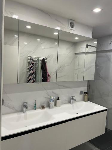 a bathroom with a white sink and a mirror at Always luxury for a luxurious life in Grimbergen